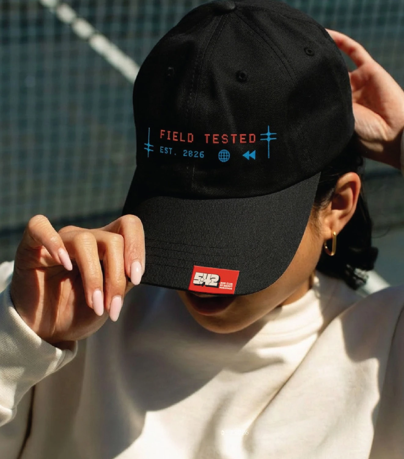 Close-up of a black cap embroidered with colored lettering